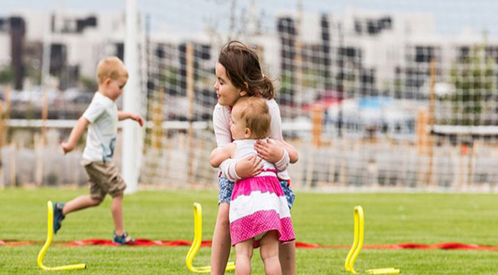 kids hugging on field